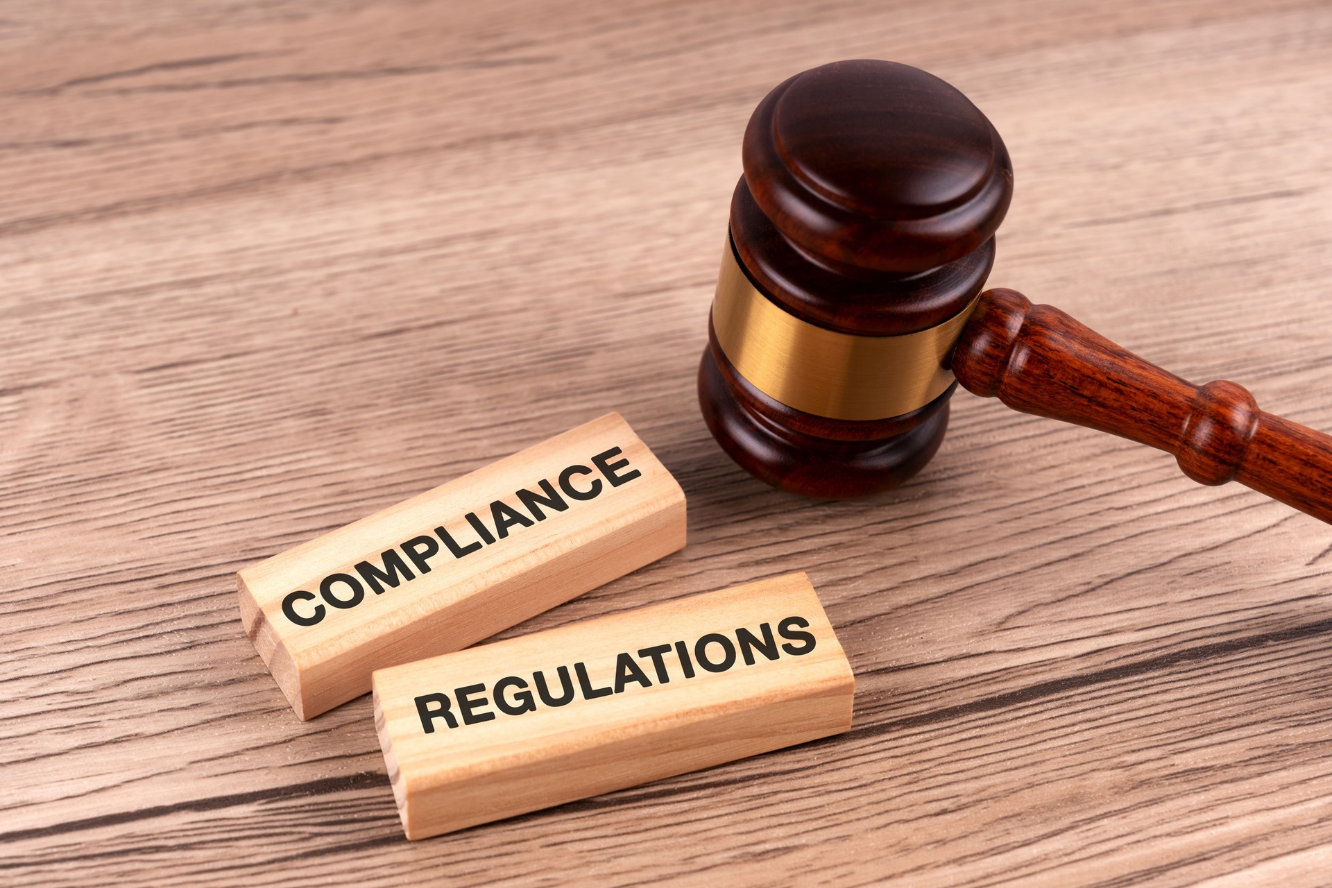 Gavel and wood block with text compliance and regulations